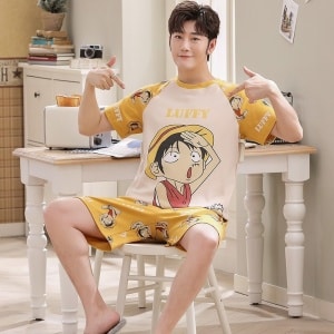 Set di maglietta e pantaloncini estivi con stampa Luffy di alta qualità, indossati da un uomo seduto su una sedia in una casa