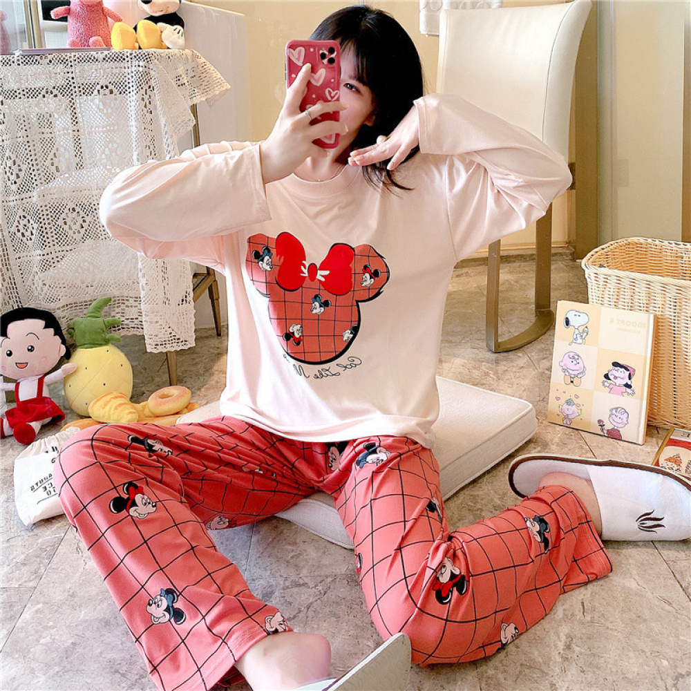 Pigiama a due pezzi in cotone con maniche lunghe e disegno di Minnie Mouse con una bambina che indossa il pigiama e uno sfondo di una stanza con animali di peluche