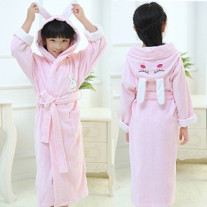 Pigiama di alta qualità in cotone rosa con coniglietto per bambine, indossato da una bambina in una casa