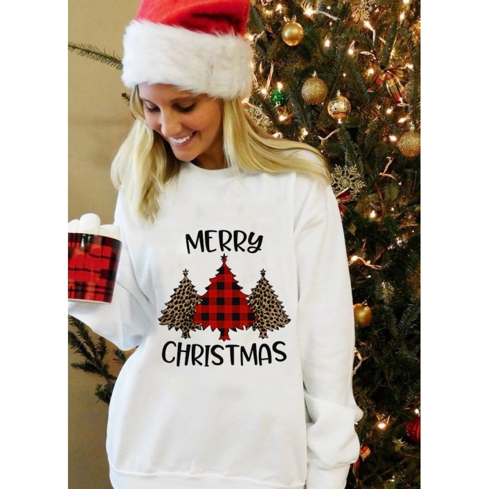 Maglia a maniche lunghe da donna con disegno di albero di Natale e scritta "Merry Christmas", indossata da una donna davanti a un albero di Natale in una casa