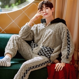 Un caldo pigiama con cappuccio per uomo, indossato da un uomo seduto su una sedia in una casa