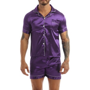 Un pigiama di raso viola indossato da un uomo con un tatuaggio sul braccio sinistro; il pigiama è composto da pantaloncini e una camicia con bottoni sul davanti
