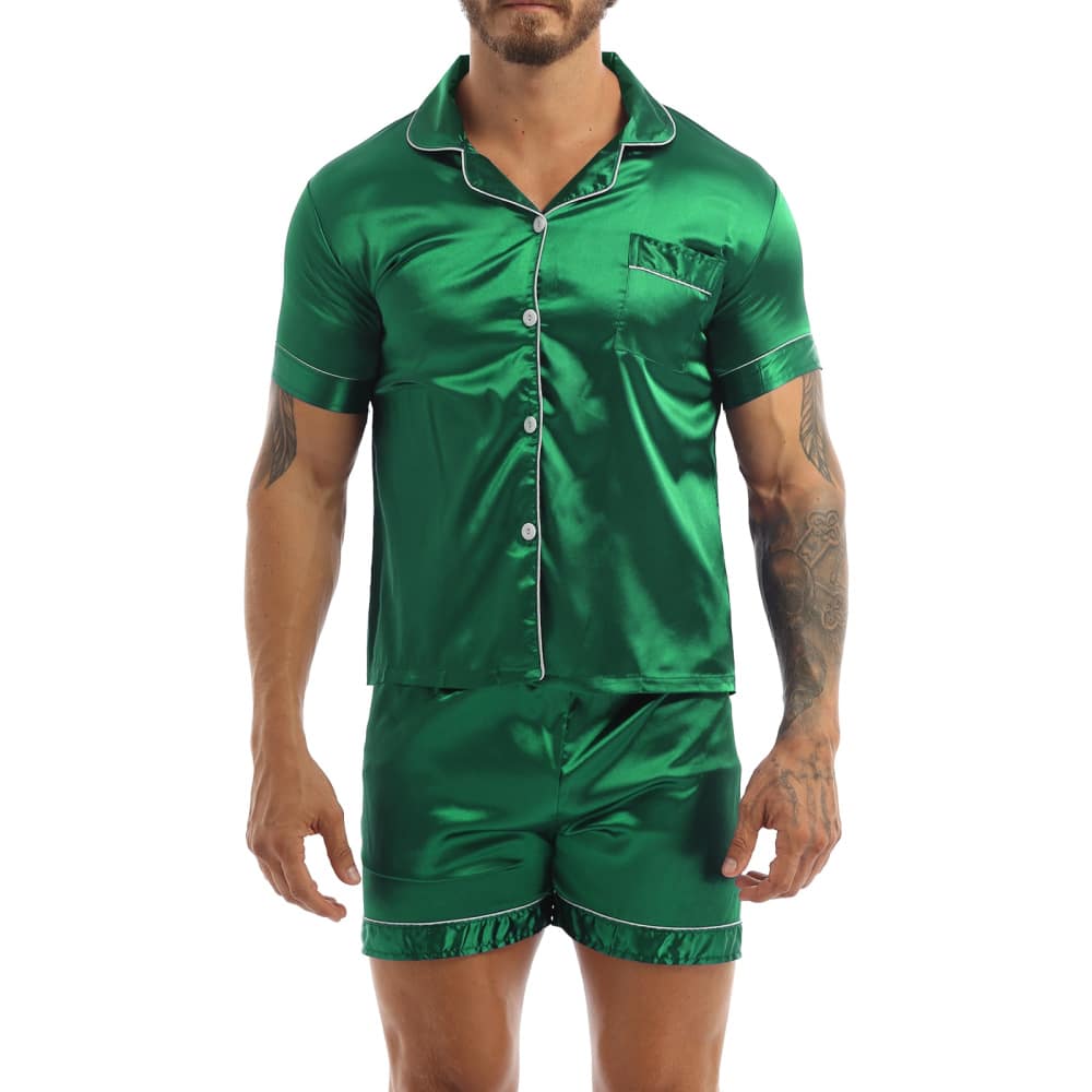 Un pigiama di raso verde indossato da un uomo con un tatuaggio sul braccio sinistro; il pigiama è composto da pantaloncini e una camicia con bottoni sul davanti