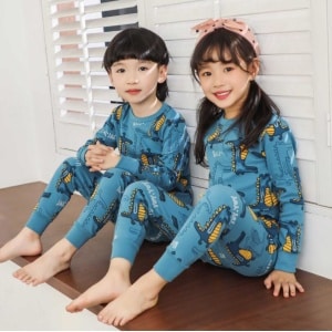 Pigiama dinosauro blu primaverile per bambini con due bambini che indossano il pigiama