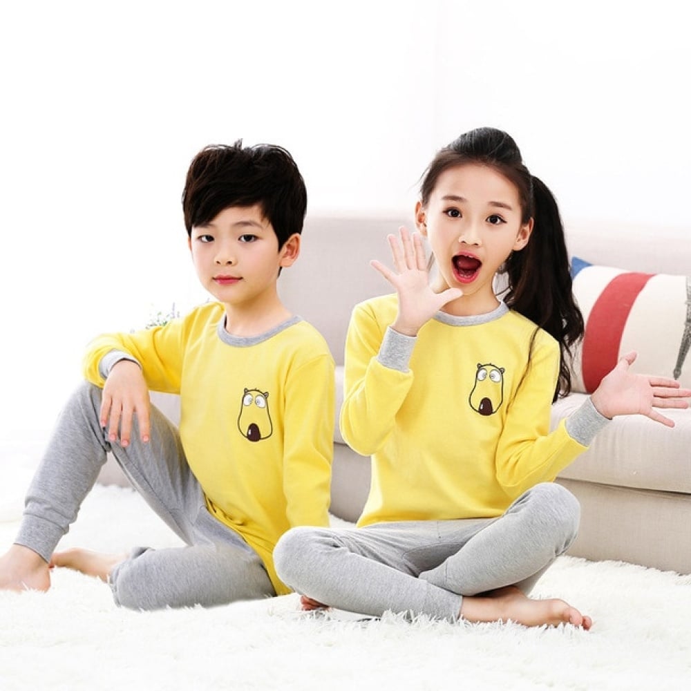 Pigiama primaverile con maglione giallo e pantaloni grigi per bambini con due bambini che indossano il pigiama