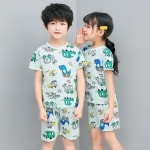 Pigiama verde a due pezzi con stampa di cartoni animati per bambini con due bambini che indossano il pigiama e uno sfondo grigio