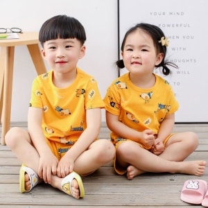Pigiama giallo a due pezzi con motivo a cartoni animati per bambini con due bambini piccoli che indossano il pigiama