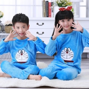 Pigiama di flanella blu a maniche lunghe con stampa di Doraemon per bambino seduto su un tappeto in una casa