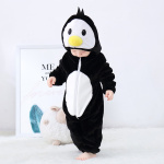Il bambino con un pigiama nero a forma di pinguino che si guarda i piedi